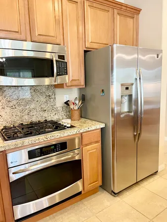 a kitchen with stainless steel appliances granite countertop a refrigerator and a sink