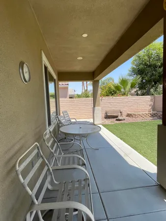 a view of a patio with table and chairs with wooden floor and fence