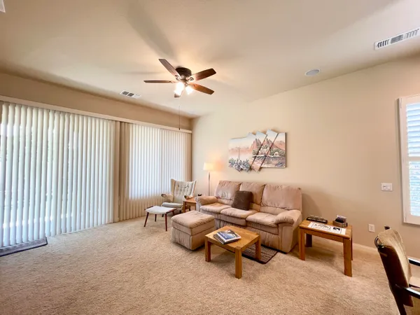 a living room with furniture and a ceiling fan