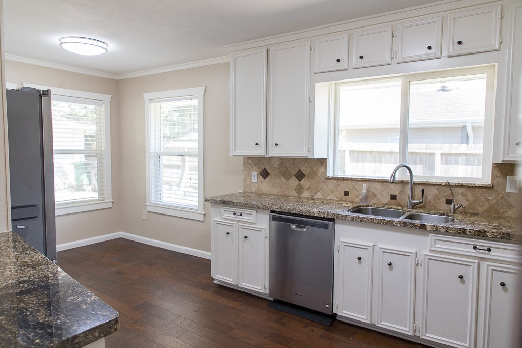 9010 Linkmeadow Lane Houston, TX 77025 - Photo 11 of 39 a kitchen with granite countertop white cabinets and a window