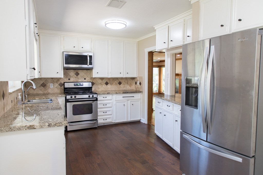 9010 Linkmeadow Lane Houston, TX 77025 - Photo 10 of 39 a kitchen with stainless steel appliances a refrigerator sink and cabinets