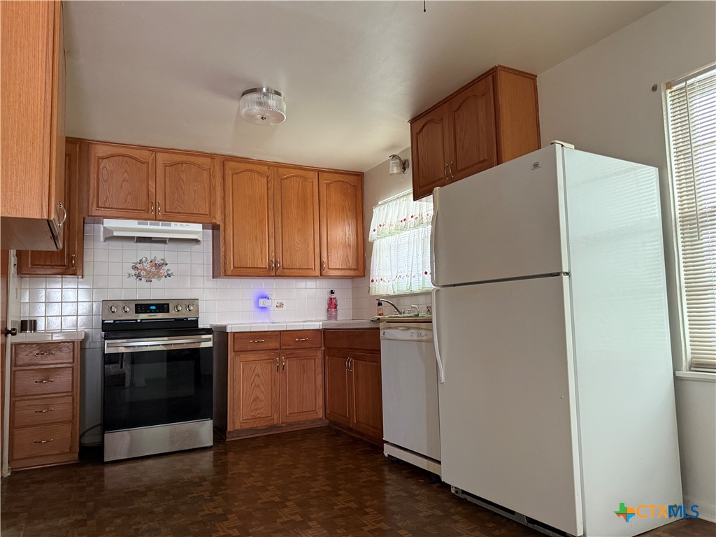 411 Cardinal Avenue Killeen, TX 76541 - Photo 6 of 14 a kitchen with a refrigerator sink and cabinets