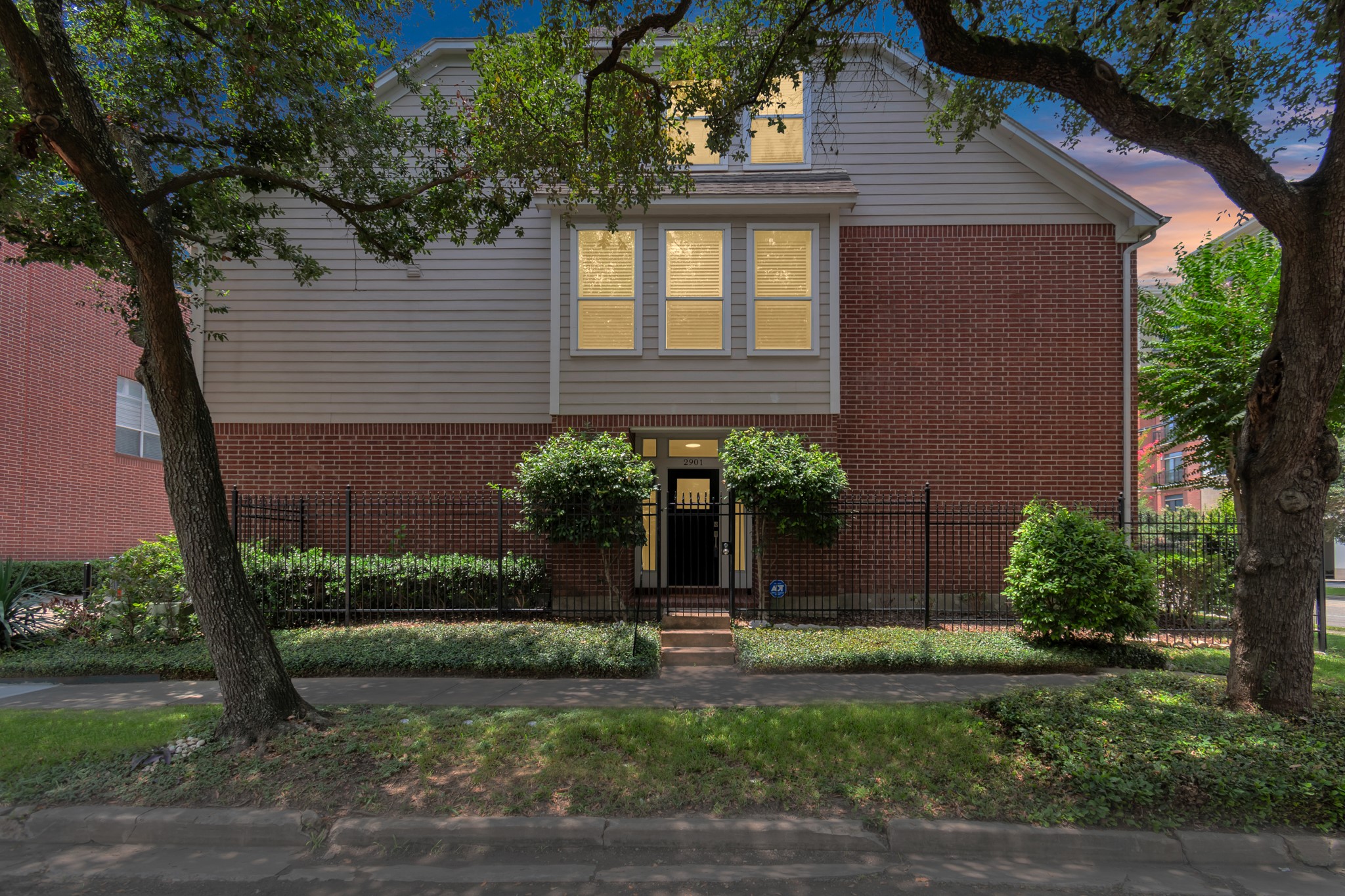 a front view of a house with a yard and potted plants