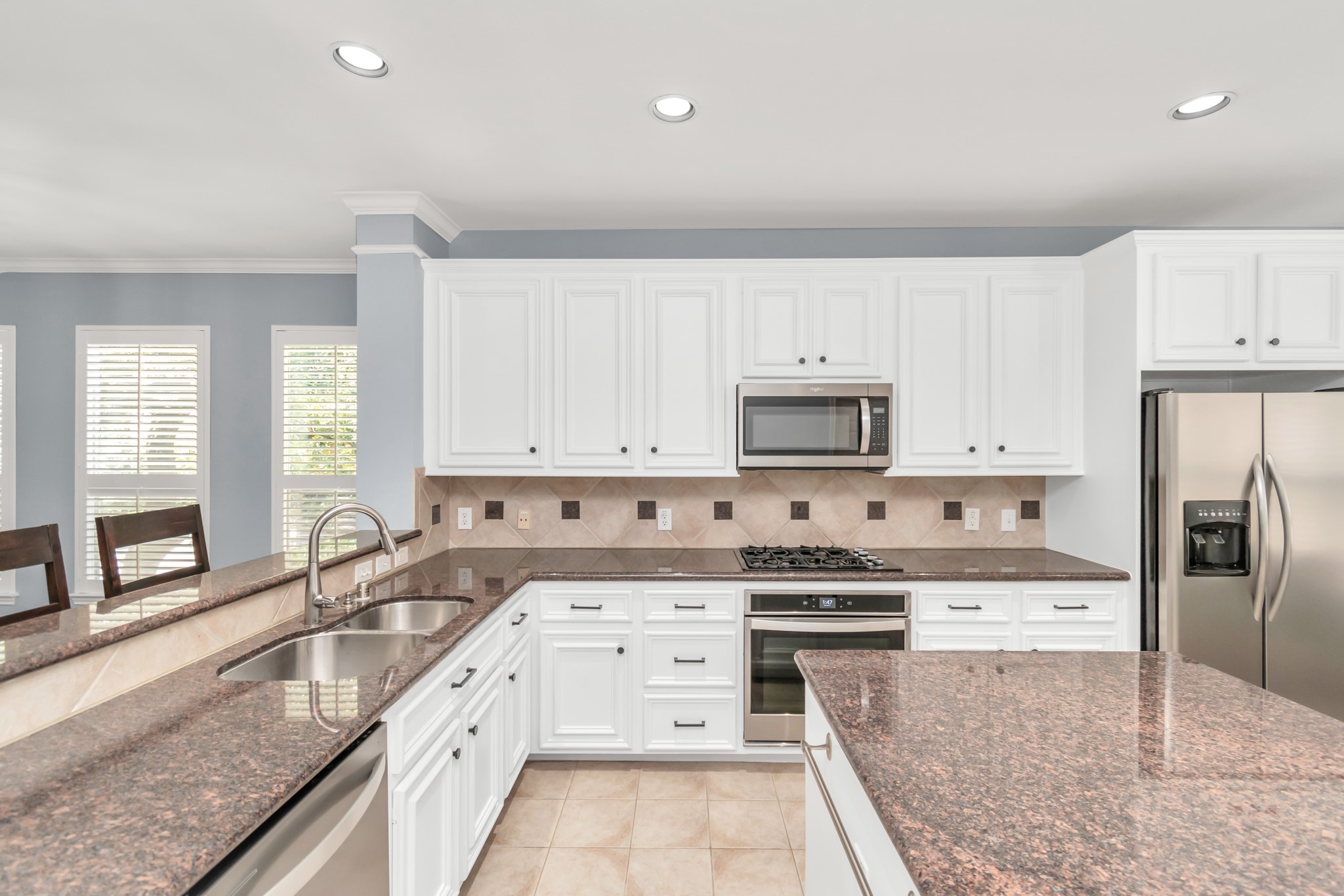2901 West Dallas Street Houston, TX 77019 - Photo 18 of 39 a white kitchen with granite countertop a stove top oven a sink a counter space and cabinets
