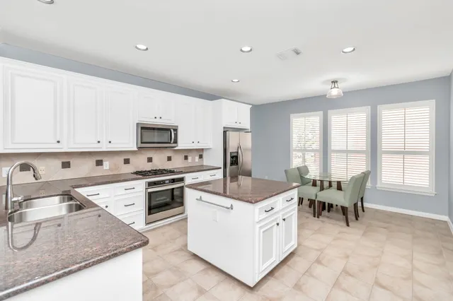 a kitchen with a stove a sink a microwave and wooden cabinets