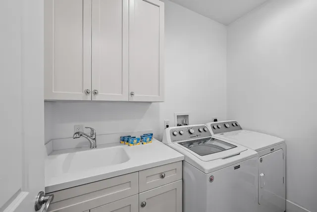 a utility room with sink dryer and washer