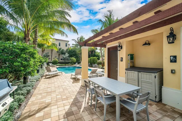 a patio with a table and chairs and potted plants
