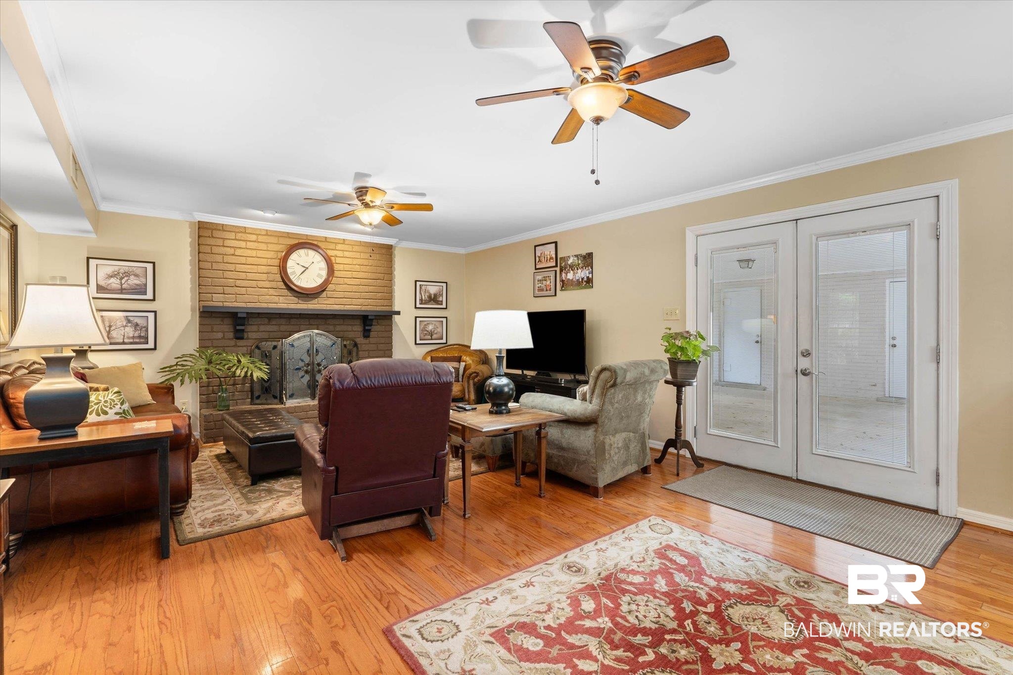 559 East Cumberland Road Mobile, AL 36608 - Photo 7 of 48 Living room with light wood-style floors, french doors, crown molding, a ceiling fan, and a brick fireplace