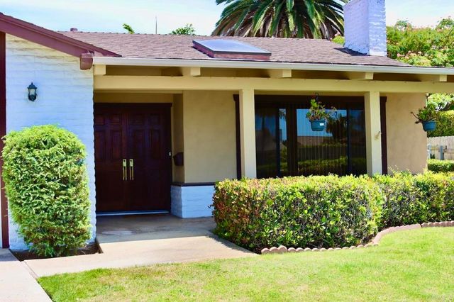 a view of a entryway door of the house with a yard
