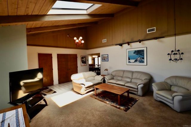 a living room with furniture and a air conditioner vent