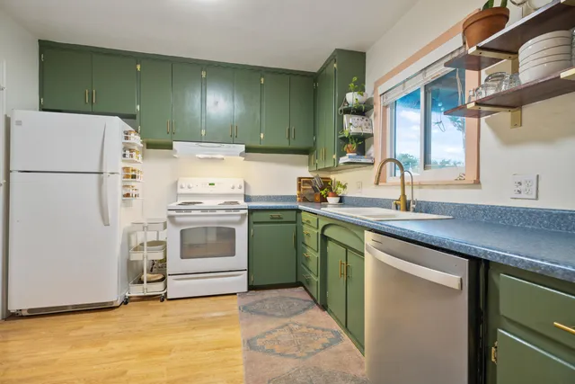 a kitchen with a sink cabinets and white stainless steel appliances