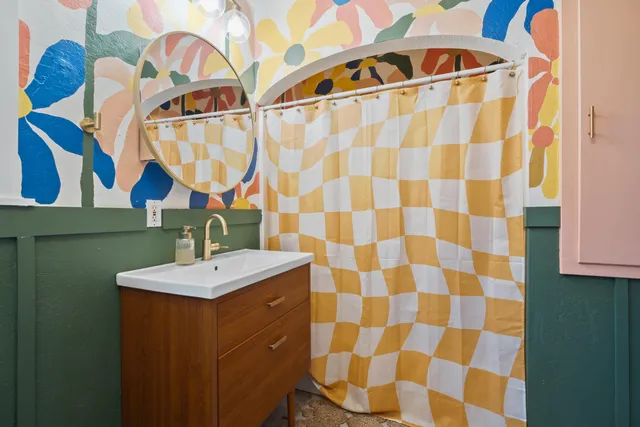a bathroom with a sink a mirror and a shower curtain