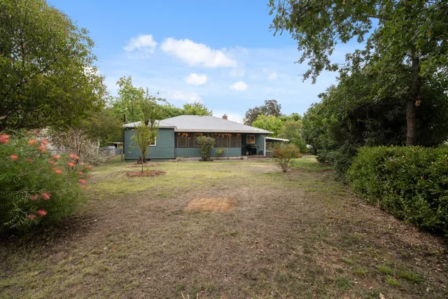 a view of a house with backyard and a tree