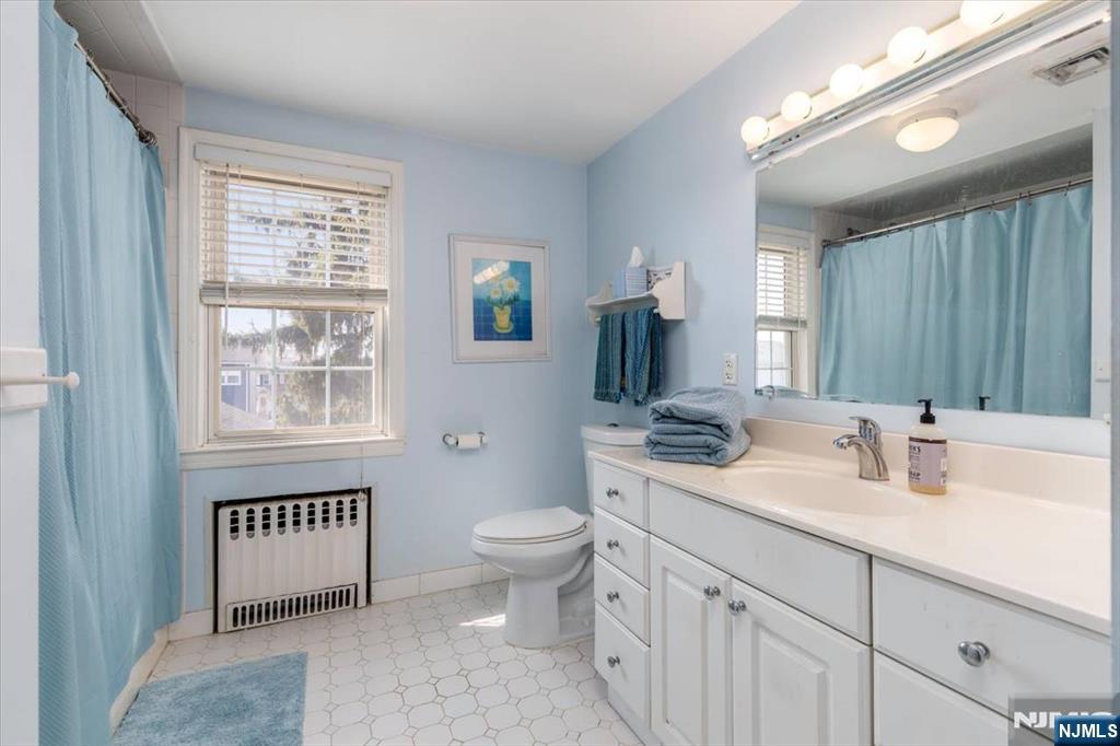 618 3rd Avenue Lyndhurst, NJ 07071 - Photo 19 of 33 a bathroom with a toilet a sink a mirror a window and vanity