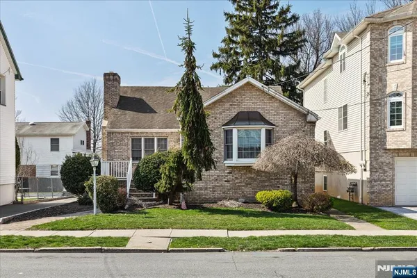 a front view of a house with a yard and potted plants