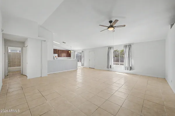 an empty room with windows and fan