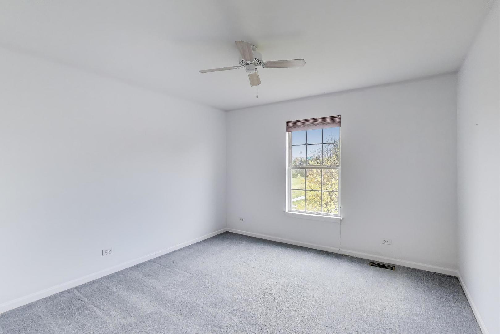 697 Providence Lane Lindenhurst, IL 60046 - Photo 18 of 31 an empty room with a window and a ceiling fan