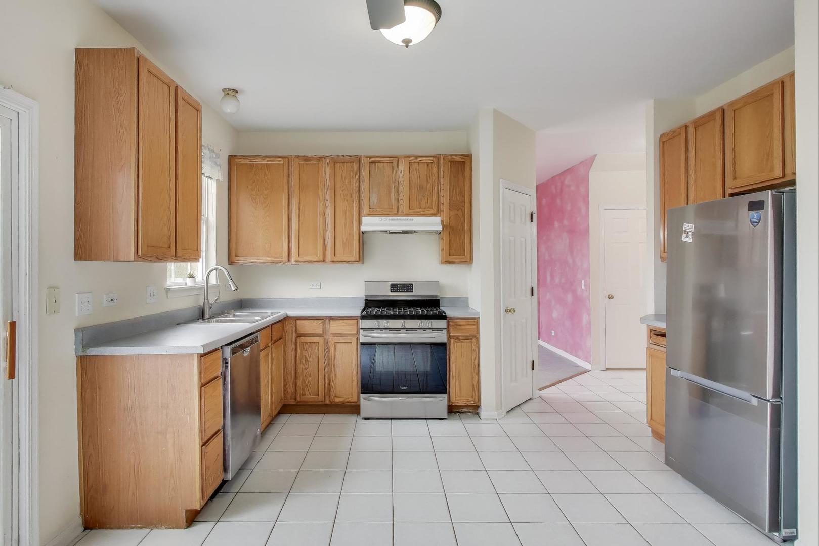 697 Providence Lane Lindenhurst, IL 60046 - Photo 9 of 31 a kitchen with stainless steel appliances granite countertop a stove a refrigerator and a sink