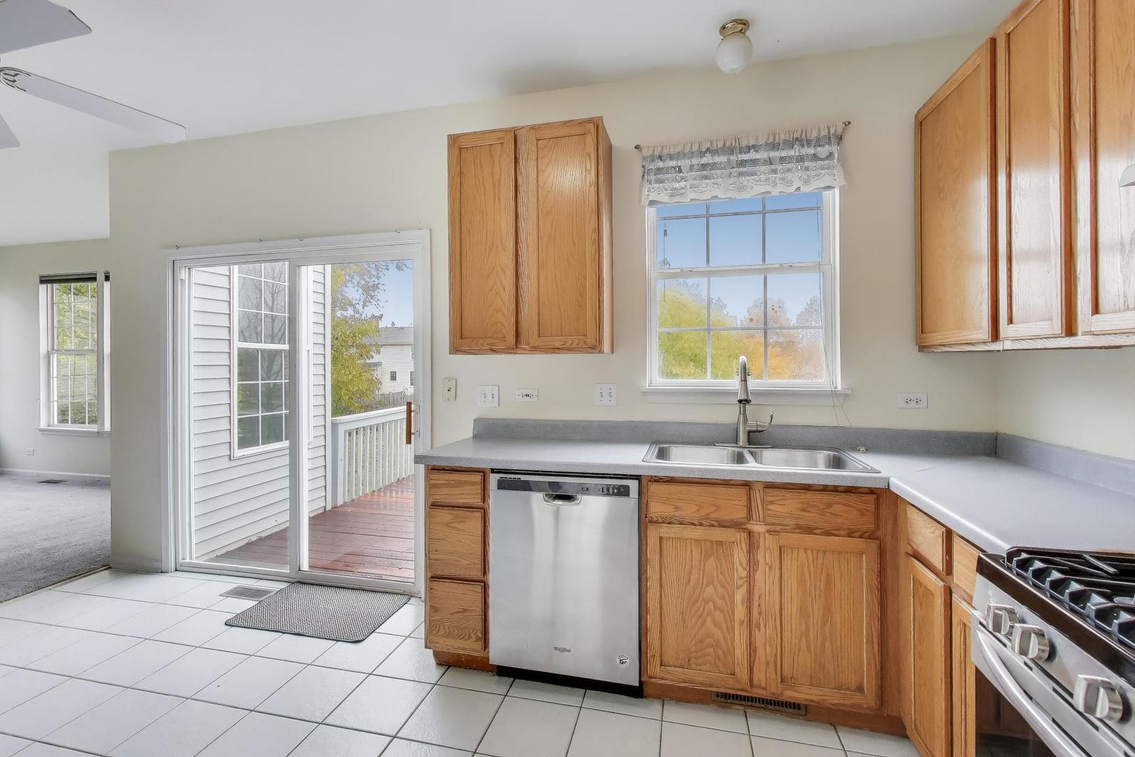697 Providence Lane Lindenhurst, IL 60046 - Photo 10 of 31 a kitchen with stainless steel appliances granite countertop a stove a sink and a microwave