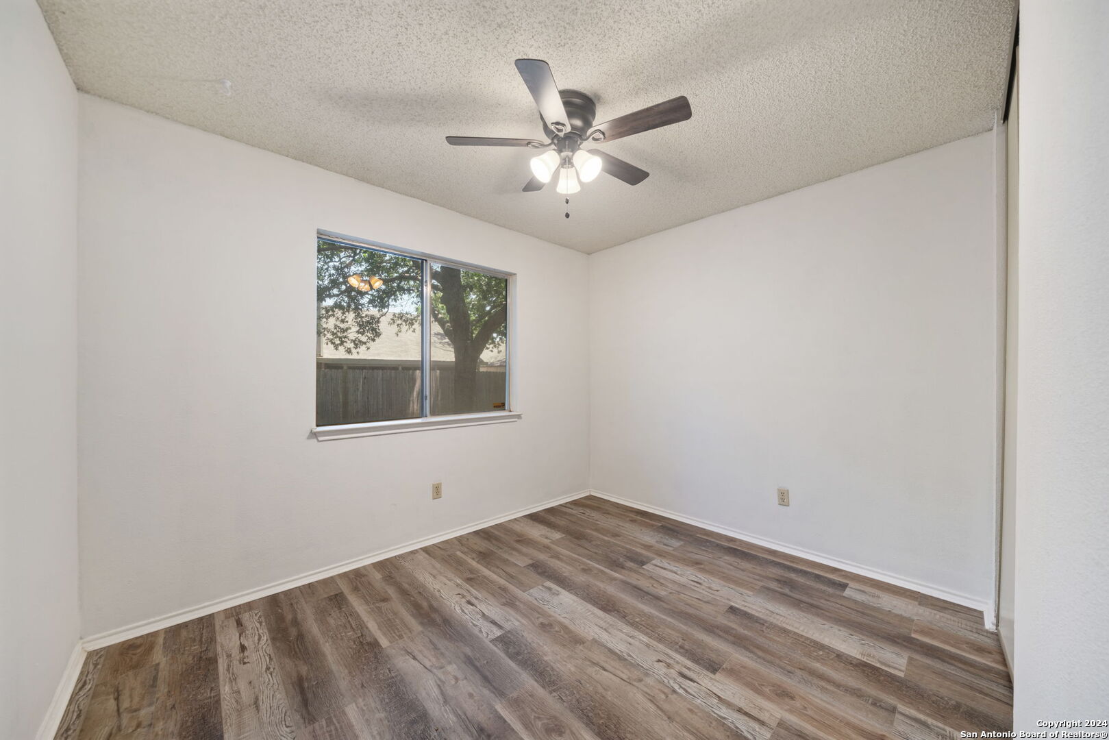 12106 Ridge Ct Street San Antonio, TX 78247 - Photo 15 of 25 an empty room with a window and a ceiling fan