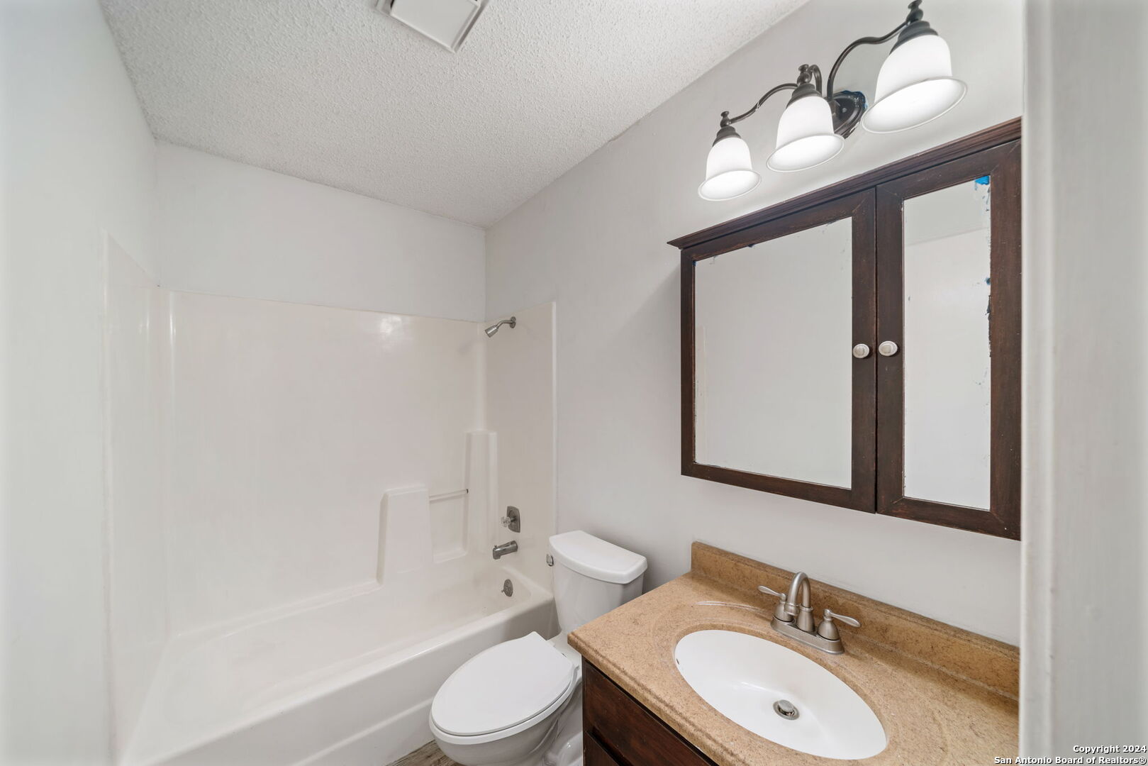 12106 Ridge Ct Street San Antonio, TX 78247 - Photo 16 of 25 a bathroom with a toilet a sink a mirror and a bathtub