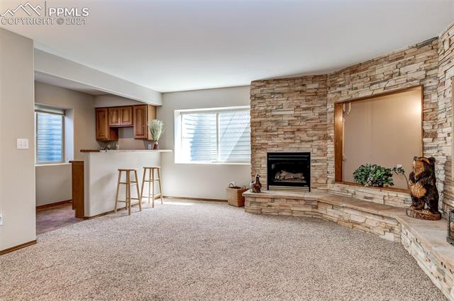 9737 Rockingham Drive Peyton, CO 80831 - Photo 19 of 28 ~The basement includes a wet bar area and a beautiful stacked stone fireplace, and area for a TV~