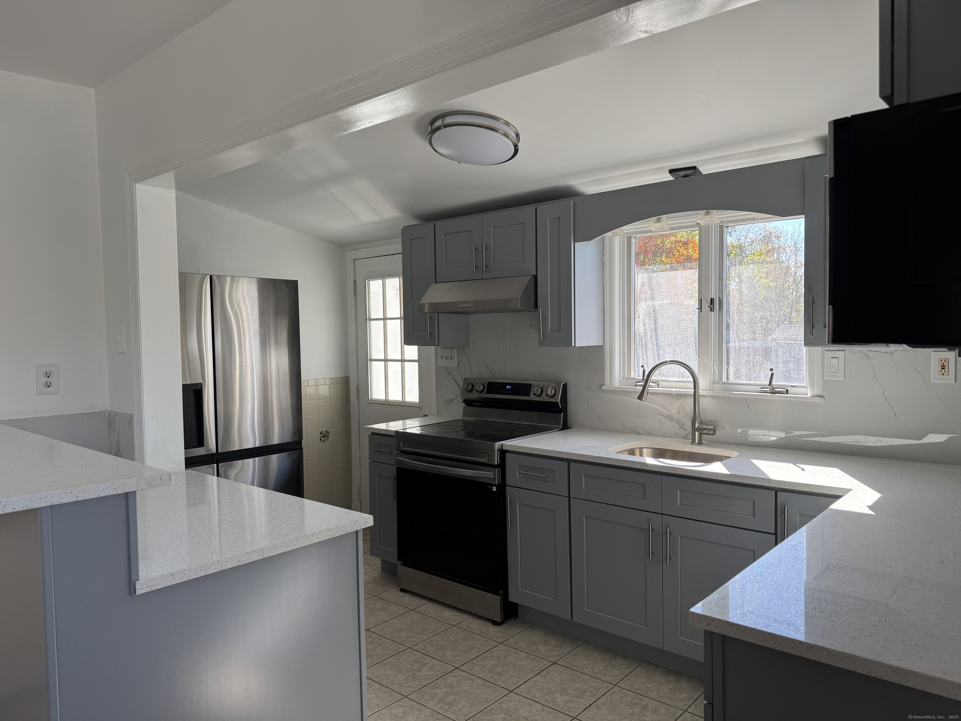 a kitchen with stainless steel appliances granite countertop a sink stove and refrigerator