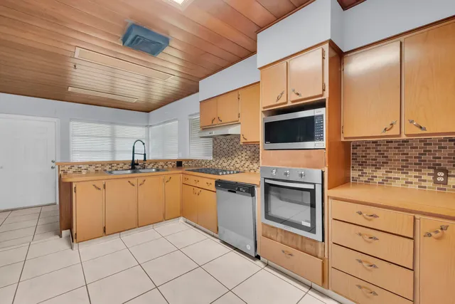 a kitchen with granite countertop cabinets stainless steel appliances and sink