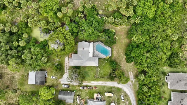 an aerial view of a house with a yard fountain and a garden