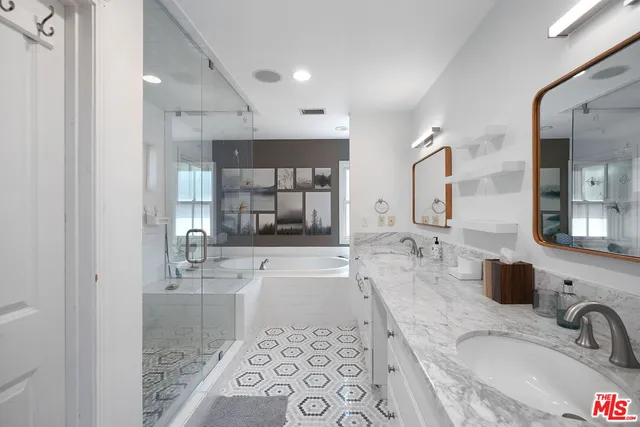 a bathroom with a granite countertop sink mirror and bathtub