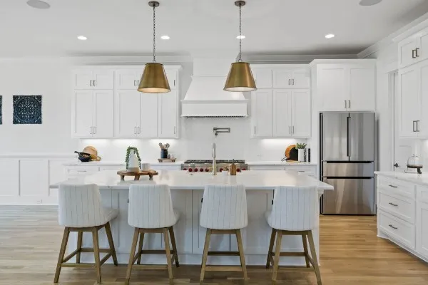 a kitchen with stainless steel appliances a dining table chairs stove and white cabinets