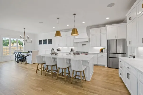 a kitchen with stainless steel appliances granite countertop a sink a stove and a wooden floors