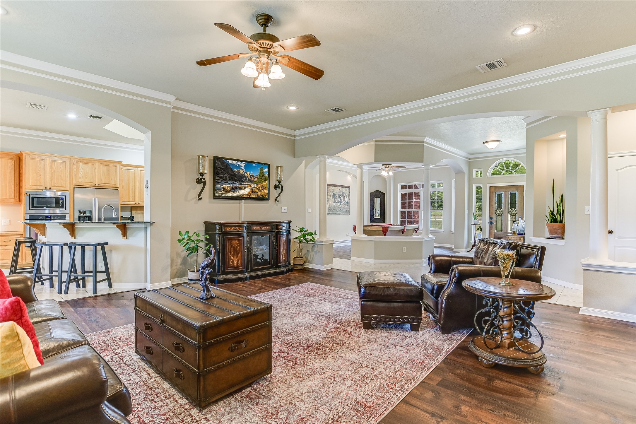 741 Knobbs Road McDade, TX 78650 - Photo 5 of 38 An inviting open-concept living area flows seamlessly into the kitchen and entry, highlighted by elegant wood flooring and arched doorways.
