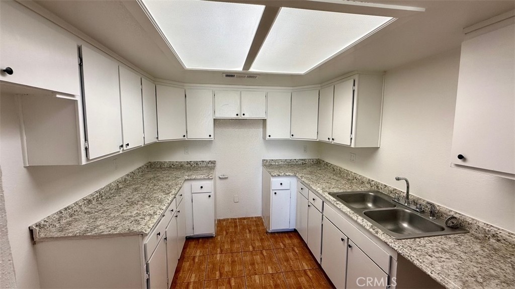 16026 K Street Mojave, CA 93501 - Photo 5 of 10 a kitchen with granite countertop a sink a stove and cabinets