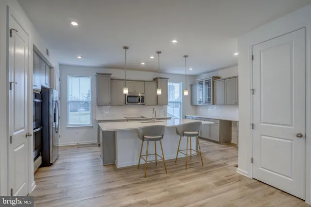 a kitchen with kitchen island granite countertop wooden cabinets and refrigerator