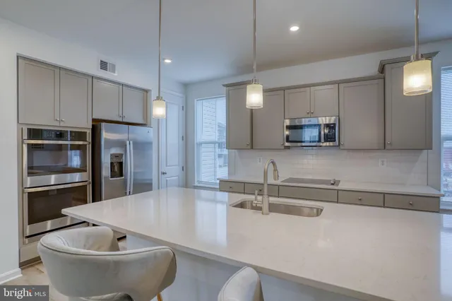a kitchen with kitchen island a dining table chairs sink and microwave