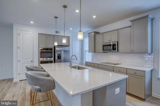 a kitchen with stainless steel appliances a sink a stove a refrigerator and cabinets