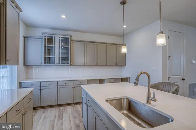 a kitchen with a sink cabinets and wooden floor