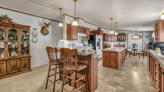 a view of a dining room and livingroom with furniture wooden floor a chandelier