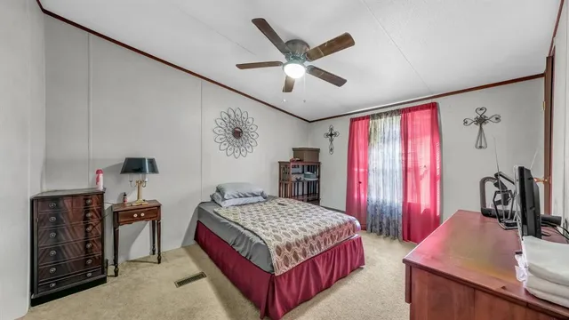 a bedroom with a large bed and a chandelier