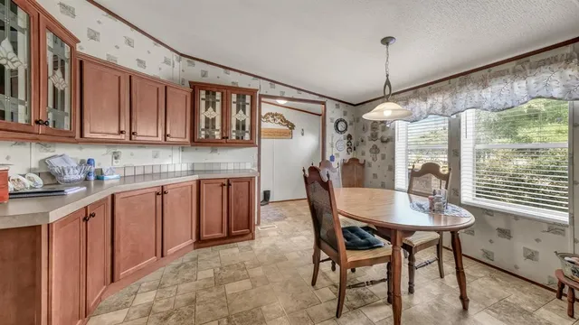 a kitchen with granite countertop a stove a table and chairs in it