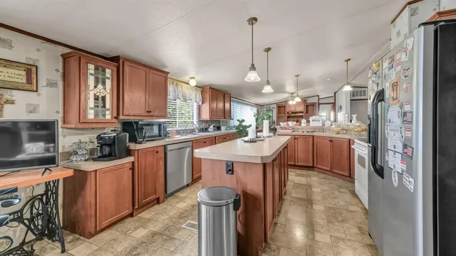 a kitchen with stainless steel appliances granite countertop a sink a stove and a refrigerator