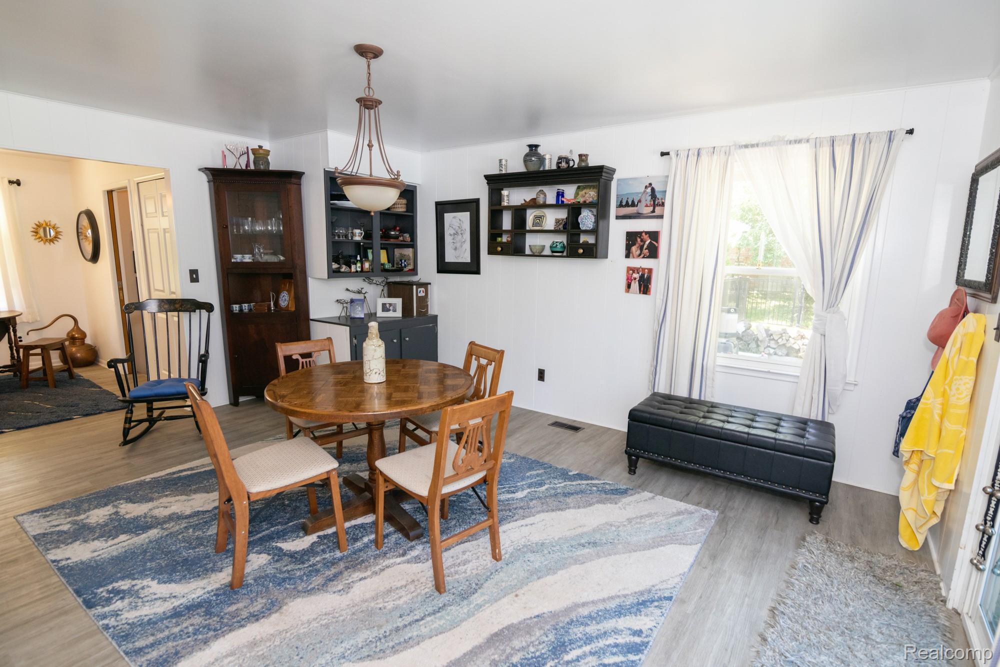 724 Sandstone Drive Rochester, MI 48309 - Photo 24 of 60 Dining area featuring wood-finish flooring and a central chandelier