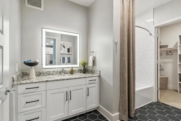 a bathroom with a granite countertop sink and a mirror