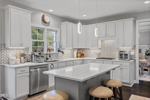 a kitchen with stainless steel appliances a sink a stove a refrigerator cabinets and a center island