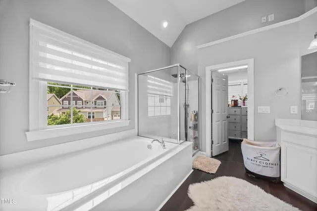 a bedroom with a large bed couch and windows