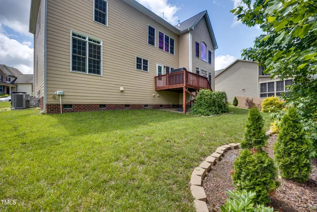 a view of house with backyard and trees in the background