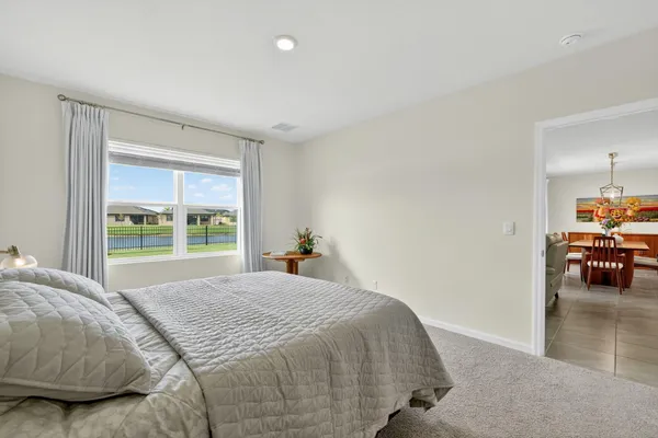 a bed sitting in a bedroom next to a window