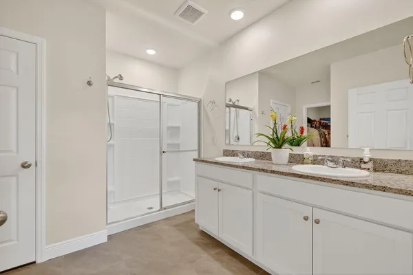 a bathroom with double sink and a mirror
