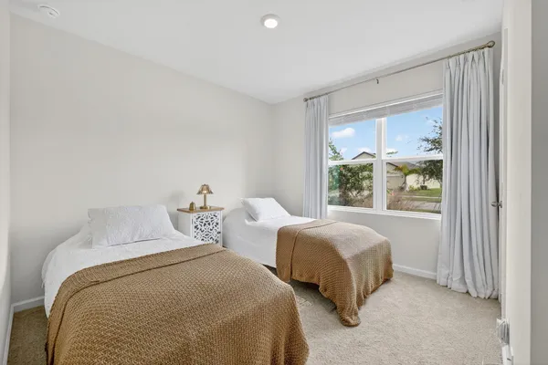 a bedroom with two beds and a window